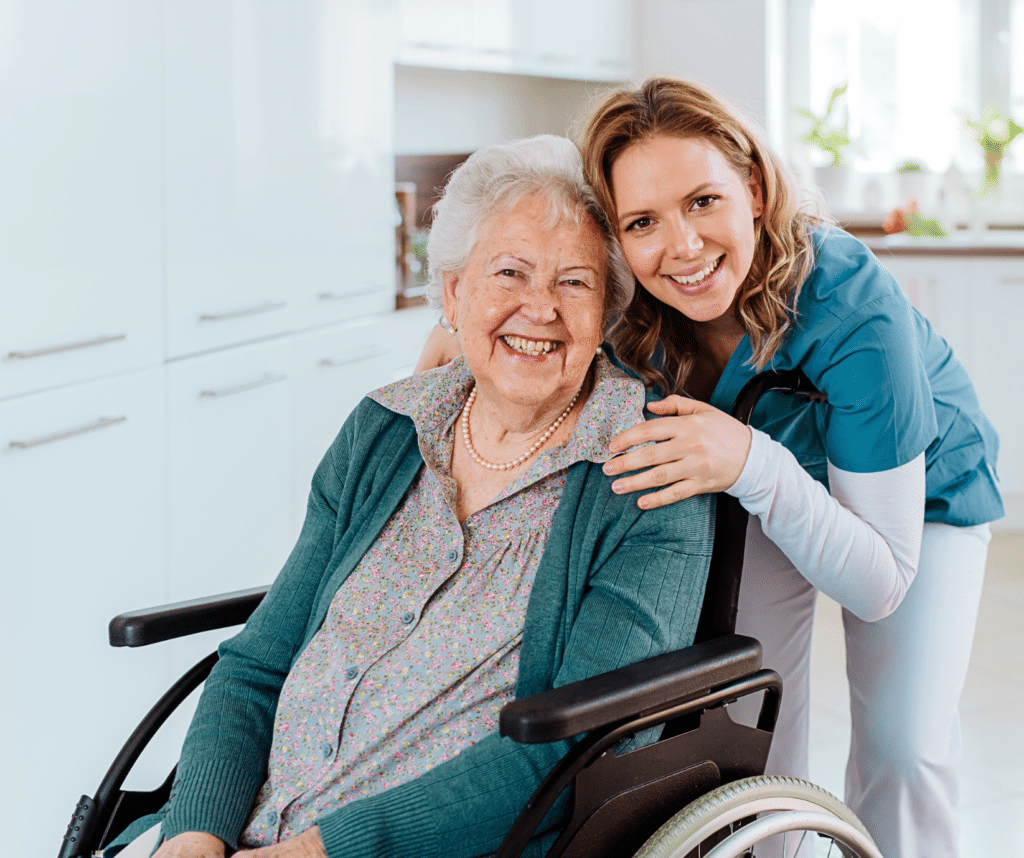 Homecare nurse inside client home with elderly client smiling in wheelchair